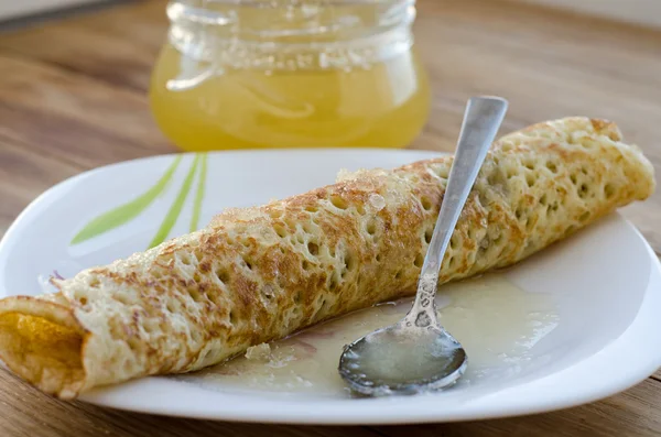 Warmgewalste pannenkoek en honing — Stockfoto