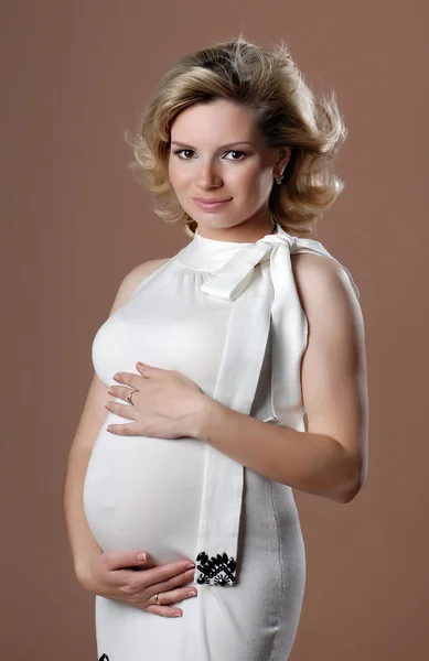 Uśmiechnięte dziewczyny w ciąży na beżowym tle. — Zdjęcie stockowe