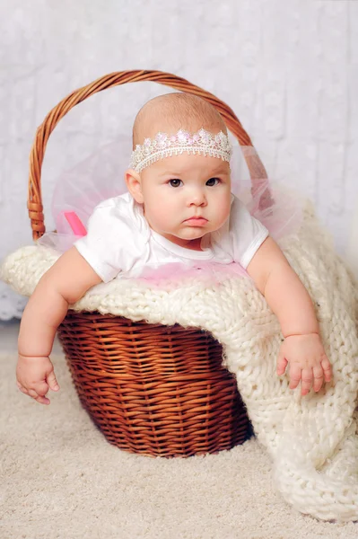 Roztomilá holčička v košíku s krajkou čelenka — Stock fotografie