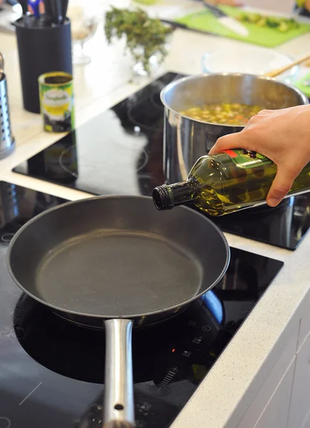 Chef-kok gonna olijfolie giet in de pan Stockafbeelding