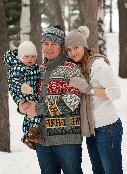 Glückliche Familie, junges Paar und ihr Sohn verbringen Zeit im Freien im Winterwald. Blick in die Kamera — Stockfoto