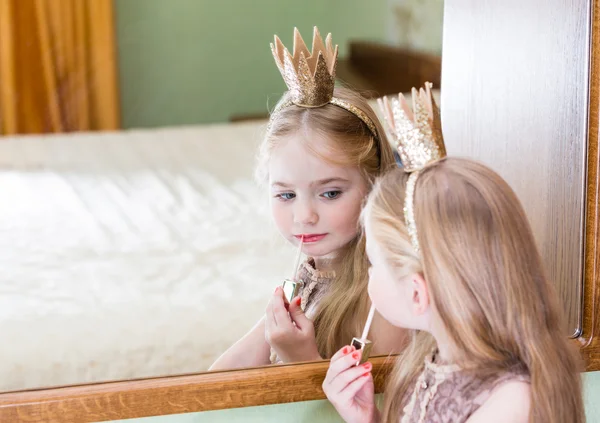 Princesa niña pintura maquillaje lápiz labial en el espejo —  Fotos de Stock