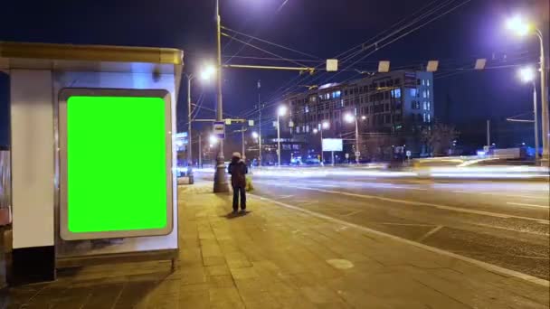 Billboard met een chroma sleutel groen scherm op n bushalte 's nachts. Tijdsverloop. — Stockvideo