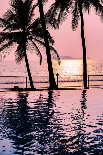 Reflejo de palmeras en una piscina azul al atardecer — Foto de Stock