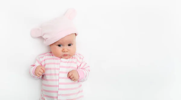 Linda niña pequeña en un sombrero rosa con orejas de conejo. Concepto de infancia. Fondo claro. Feliz emoción. Copyspace. Quédate en casa. Tapa maqueta. Niños ropa rosa — Foto de Stock