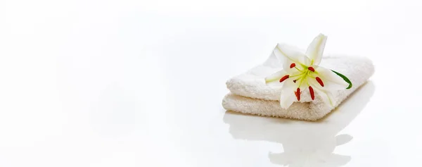 Toallas de spa blancas con lirio sobre blanco y reflejo — Foto de Stock