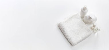 Beyaz spa havlusu ve şişeler dolusu vücut bakımı.