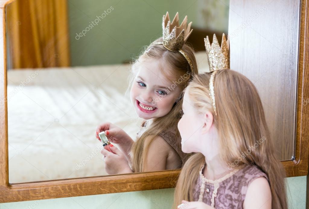 The little princess looks in the mirror