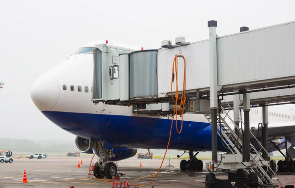 O avião no aeroporto de carga de passageiros — Fotografia de Stock