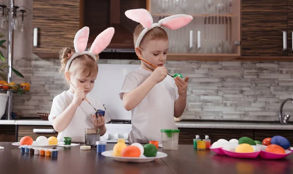 happy Easter. funny and happy children a boy and a girl with bunny ears play, prepare for the holiday and paint eggs.