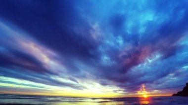 Denizin üzerinde bulutlu gün batımı gökyüzü.