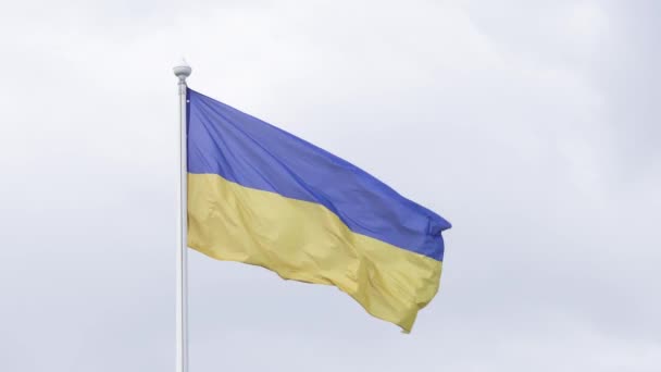 Ukraiński flaga powiewa na wiatr, na tle zachmurzone niebo. (Uhd 4k) — Wideo stockowe