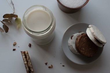 Arjantin alfajore ile bir bardak süt Dulce de leche ile doldurulmuş ve çikolatayla kaplı