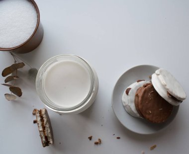 Arjantin alfajore ile bir bardak süt Dulce de leche ile doldurulmuş ve çikolatayla kaplı