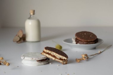 Arjantin alfajore ile bir bardak süt Dulce de leche ile doldurulmuş ve çikolatayla kaplı