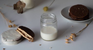 Çikolata kaplı bir bardak taze süt. Dul de leche alfajores.