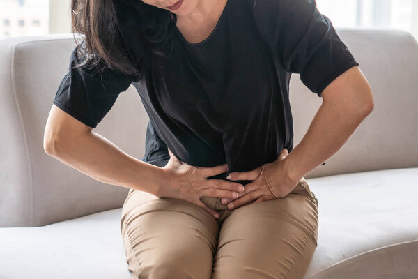 Abdominal pain in woman with stomachache illness from menstruation cramps, stomach cancer, irritable bowel syndrome, pelvic discomfort, Indigestion, Diarrhea or GERD (gastro-esophageal reflux disease)