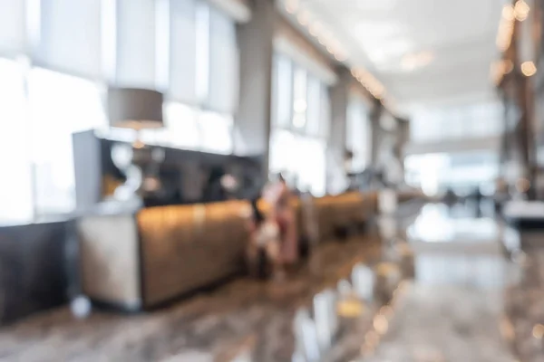 Hotel or office building lobby blur background interior view toward reception hall, modern luxury white room space with blurry corridor and building glass wall window