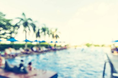 Otel havuz başı partisi için bulanık yüzme havuzu arka planı. Mavi serin gökyüzü ve bulanık tropik palmiye ağacı ve plaj şemsiyesi olan yaz partisi.