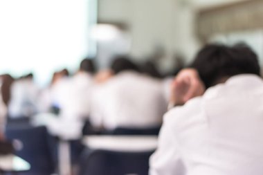 Görüntü okulunun arka planı. Üniversite öğrencileri sınav sorularına cevap yazıyorlar.