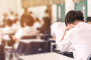 Görüntü okulunun arka planı. Üniversite öğrencileri sınav sorularına cevap yazıyorlar.