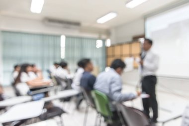 Bulanık soyut arka plan üniversite öğrencileri seminer odasında sınıfın önünde öğretmenleriyle oturuyor. 