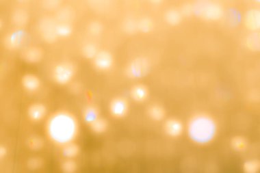 Tatil partisinin kristal küresinin parlak ışığının bulanık sarı arka planı.