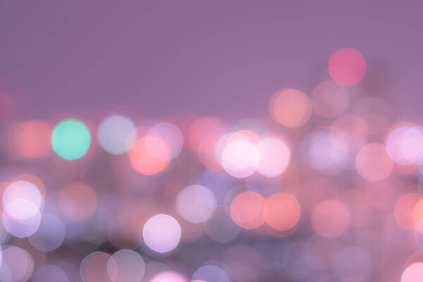 Blur background of colorful bokeh night lights of city aerial view of Bangkok in light purple pink color tone in nostalgic mood
