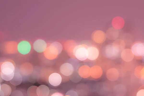 Blur background of colorful bokeh night lights of city aerial view of Bangkok in light pink color tone in nostalgic mood
