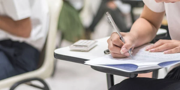 模糊的学校背景大学生在课堂上写答题 — 图库照片