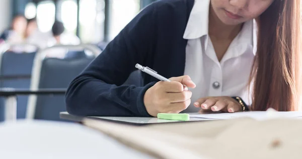 模糊的学校背景大学生在课堂上写答题 — 图库照片