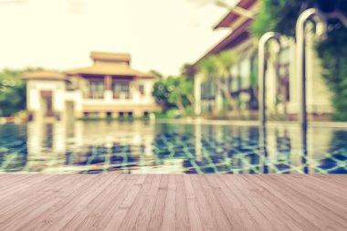 Ahşap zemin yazın arka planı bulanık otel havuzunda mavi yüzme havuzu suyu