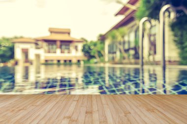 Ahşap zemin yazın arka planı bulanık otel havuzunda mavi yüzme havuzu suyu