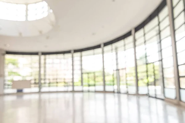 Blur background interior view looking out toward to empty office lobby and entrance doors and glass curtain wall