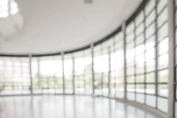 Blur background interior view looking out toward to empty office lobby and entrance doors and glass curtain wall