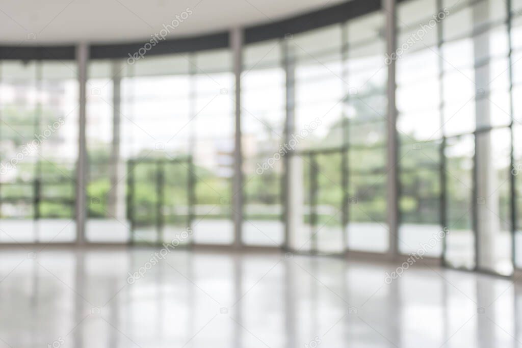 Blur background interior view looking out toward to empty office lobby and entrance doors and glass curtain wall 