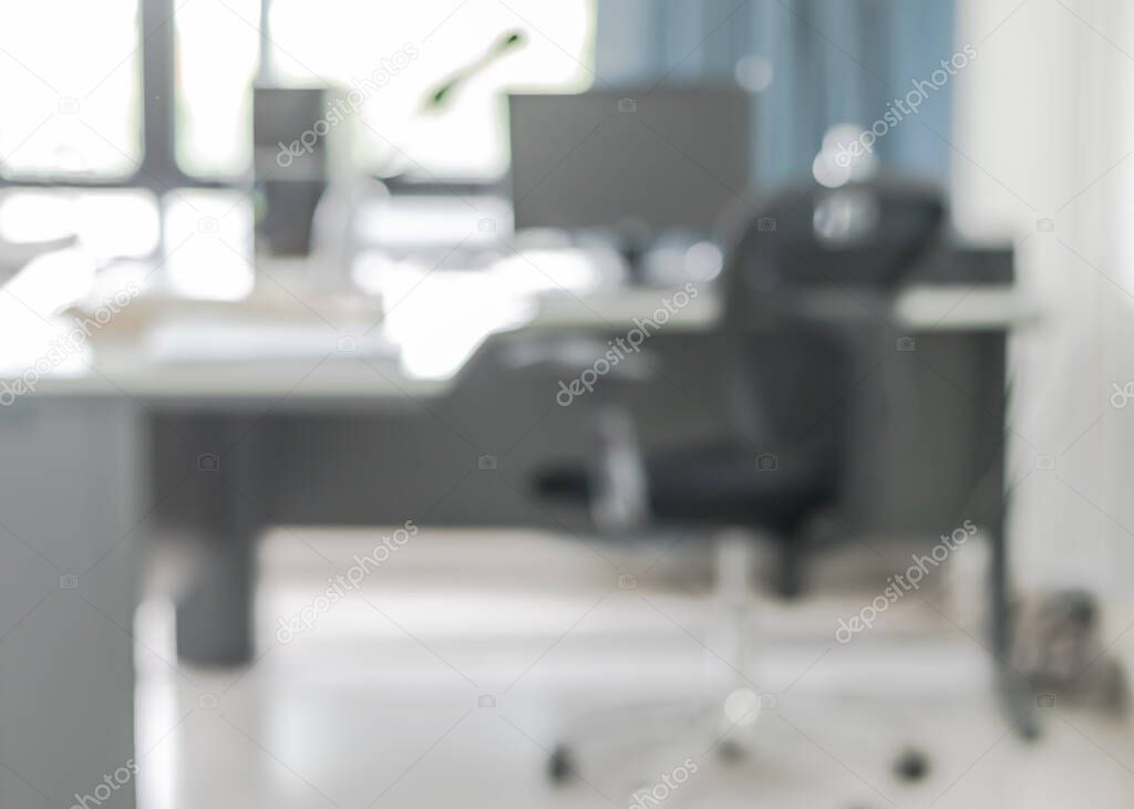 Blur background interior business office working space with pc personal computer screen in white room near glass window and wall