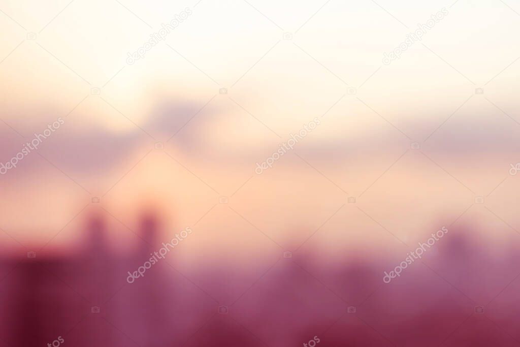 Vintage style blur background evening orange light cityscape downtown view with bright sky cloud sun flare and bokeh 