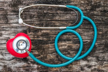 Sağlık sigortası ve dünya kalp sağlığı günü konsepti. Doktorun steteskopuyla kırmızı kalp aşkı. 