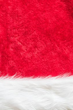 Kırmızı kadife kumaş arka plan ve Noel Baba moda kostümünün yumuşak tüylü beyaz kürk parçası ve Xmas dekorasyon unsuru için şapka aksesuarı.