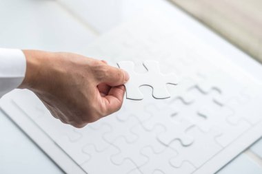 İş adamının elindeki yapboz oyunu parçası 