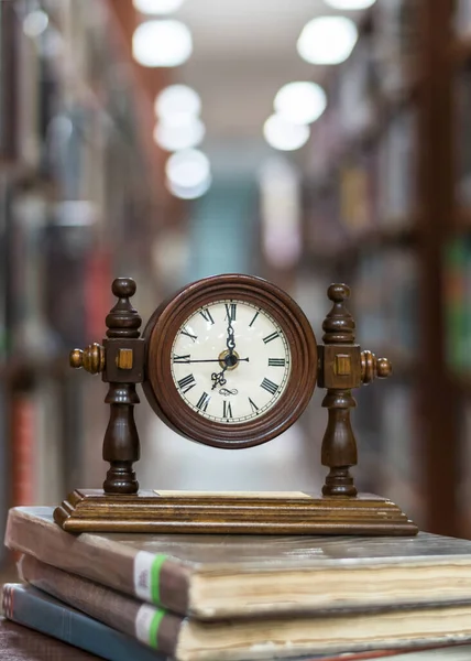 Relógio Alarme Velho Pilha Livro Com Borrão Abstrato Fundo Biblioteca — Fotografia de Stock