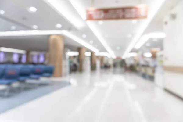 Medical clinic blur background healthcare hospital service center in OPD - outpatient department blurry interior white waiting lobby room with patient\'s , doctors, nurse staff station counter area