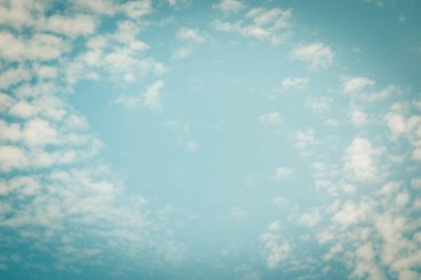 Mavi gökyüzü, arka planı bulanıklaştırdı. Eski tarz kağıt dokusunda aşk kalp bulutları.