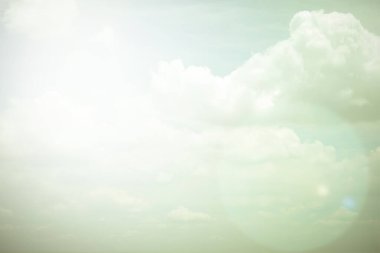 Yumuşak kabarık bulutlu, klasik renkli, güneşli bir gökyüzü. 