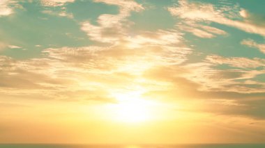 Günaydın gündoğumu ya da günbatımı akşam gökyüzü bulutlu ve erken güneş ile okyanus deniz ufkunun üzerinde yükselen Yansıtıcı dalgalı su silueti ile erken kuş, yeni gün ya da tatil başlıyor