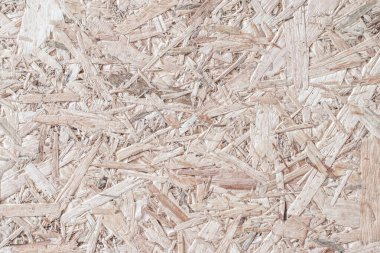 Chipboard, OSB yönelimli parçacık geri dönüştürülmüş ahşap panel zemin üzerinde doğal bej kahverengi arkaplan ve tahtadan fiber desenler var.