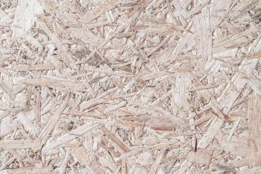 Chipboard, OSB yönelimli parçacık geri dönüştürülmüş ahşap panel zemin üzerinde doğal bej kahverengi arkaplan ve tahtadan fiber desenler var.