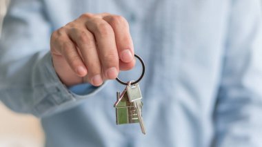 Ev sahibinin anahtarı, gayrimenkul satıcısı ya da ev sigortacısı. Kiracıya, kiracıya, alıcıya, yeni aile sahibine, emlak sigortası kavramına el uzatıyor.