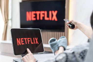 Bangkok, Tayland - 13 Temmuz 2021: Netflix uygulama logosu, ipad ve akıllı televizyon ekran paylaşımı, yeni normal yaşam tarzında film izlemek için ev oturma odasında